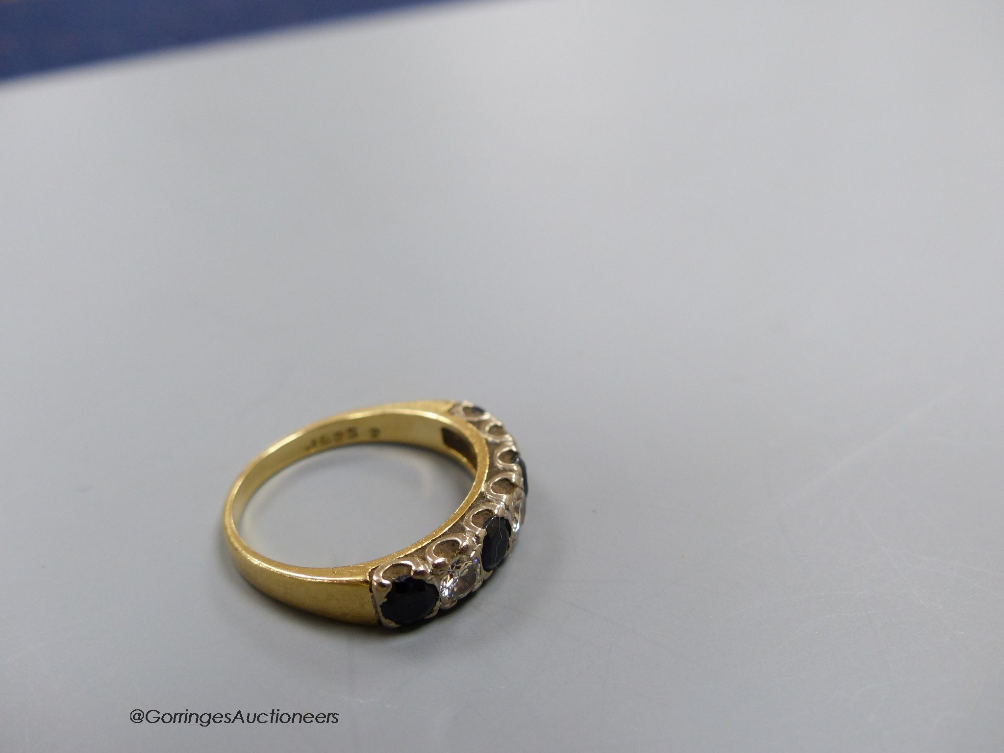 An 18ct gold sapphire and diamond seven stone ring, size N, gross 4g.